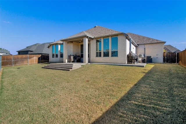 back of house with central AC, a yard, and a patio