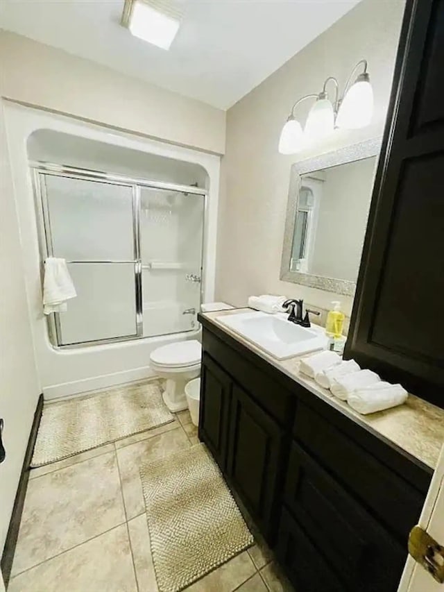 full bathroom featuring enclosed tub / shower combo, tile patterned floors, vanity, and toilet