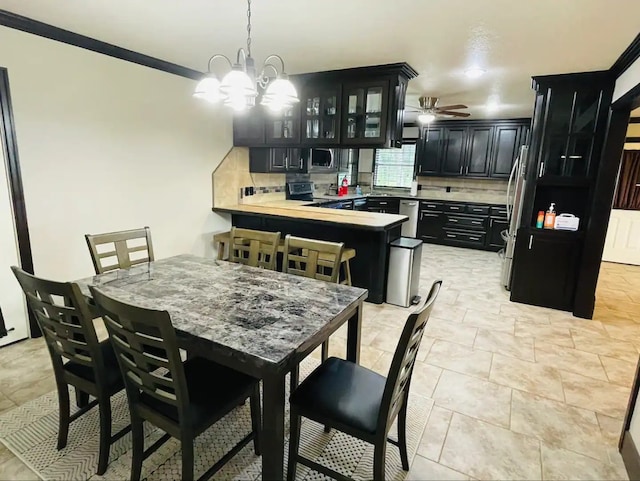 dining room with ceiling fan with notable chandelier and crown molding