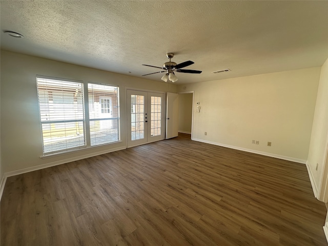 empty room featuring a textured ceiling, ceiling fan, french doors, and dark hardwood / wood-style floors