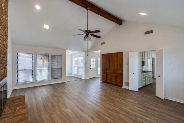 unfurnished living room featuring beamed ceiling, hardwood / wood-style floors, ceiling fan, a brick fireplace, and high vaulted ceiling