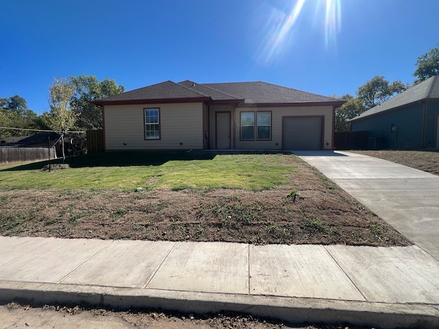 ranch-style house featuring a front lawn and a garage