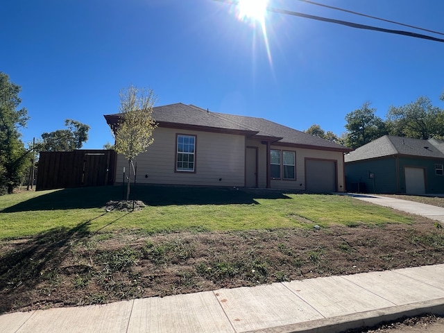 single story home featuring a garage and a front lawn