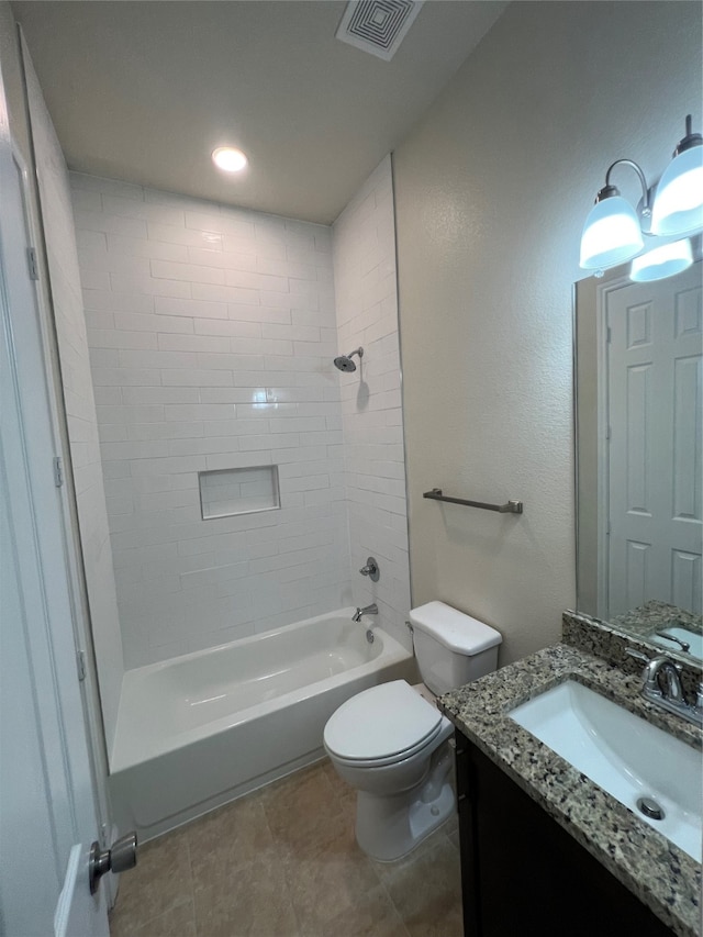 full bathroom with tile patterned flooring, tiled shower / bath, vanity, and toilet