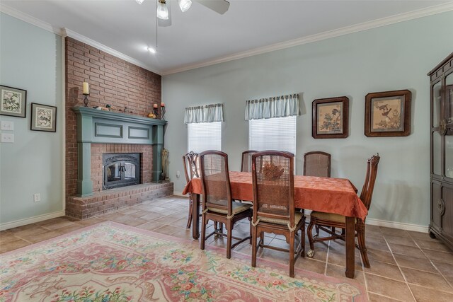 tiled dining space with ornamental molding, ceiling fan, and a fireplace