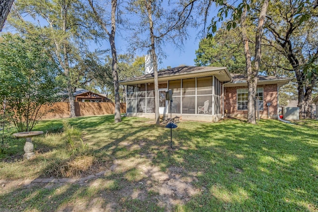 rear view of property with central AC, a sunroom, and a lawn