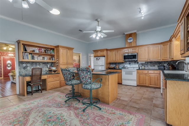 kitchen with ceiling fan, a kitchen island, sink, and white appliances