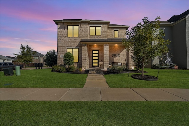 view of front of property featuring brick siding, a porch, and a front yard