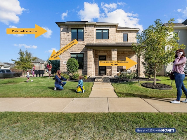 view of front facade with brick siding and a front yard