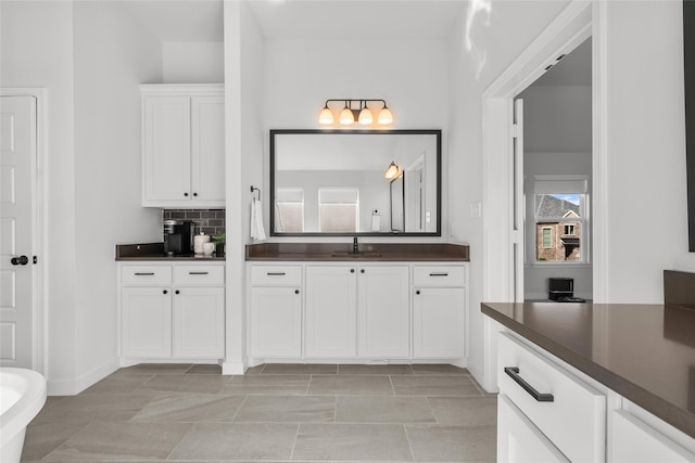 bathroom with tile patterned floors, vanity, and tasteful backsplash