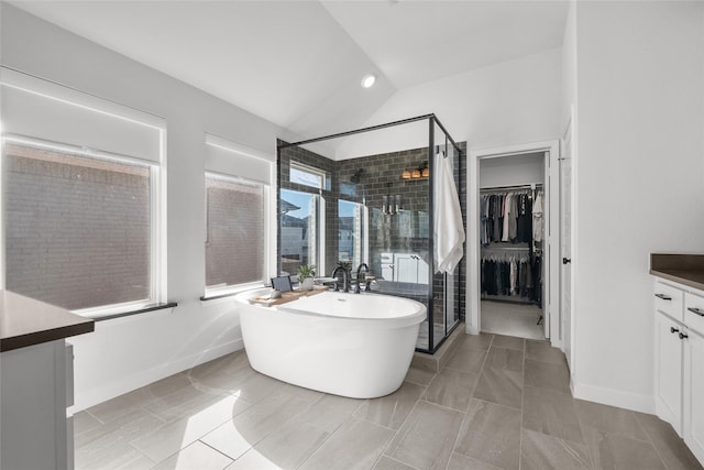 bathroom with tile patterned floors, vanity, plus walk in shower, and lofted ceiling