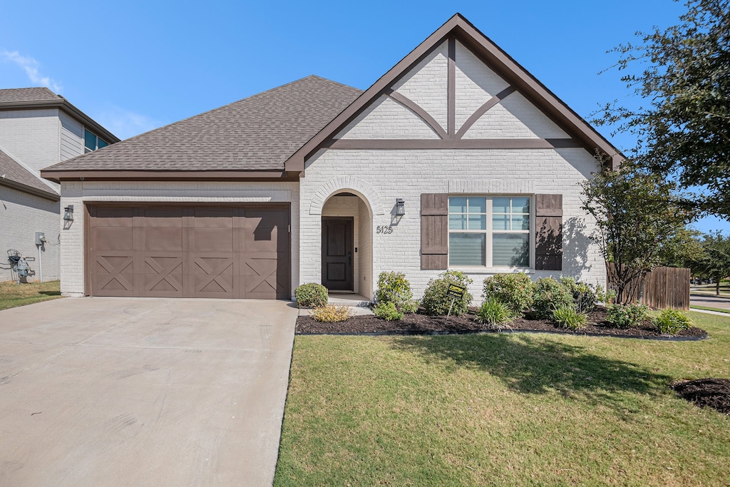 view of front of home featuring a front yard and a garage