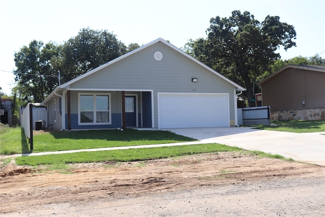 view of front of property with a garage, a front lawn, and central AC