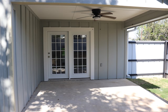 view of exterior entry with ceiling fan and a patio