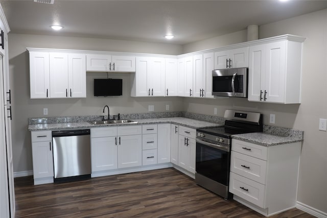 kitchen featuring appliances with stainless steel finishes, sink, dark hardwood / wood-style flooring, and white cabinetry