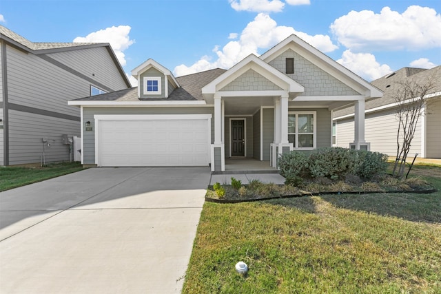 view of front of home with a garage, a front lawn, and covered porch