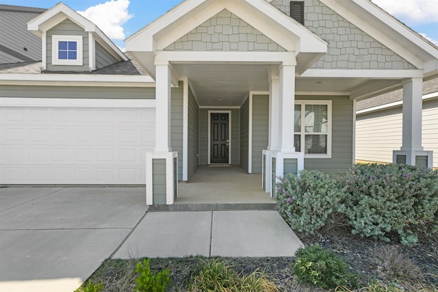 view of exterior entry featuring a garage and covered porch