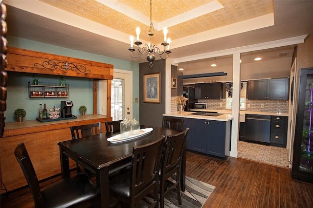 dining space with a notable chandelier, a tray ceiling, and dark hardwood / wood-style floors