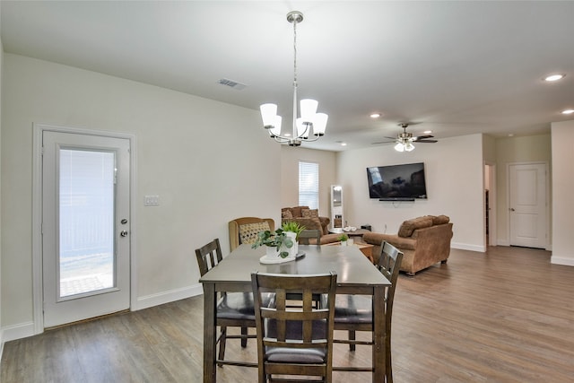 dining room with ceiling fan with notable chandelier and hardwood / wood-style flooring