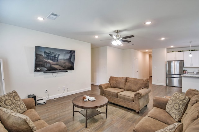 living room with hardwood / wood-style flooring and ceiling fan