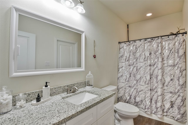 bathroom with a shower with curtain, vanity, toilet, and hardwood / wood-style flooring