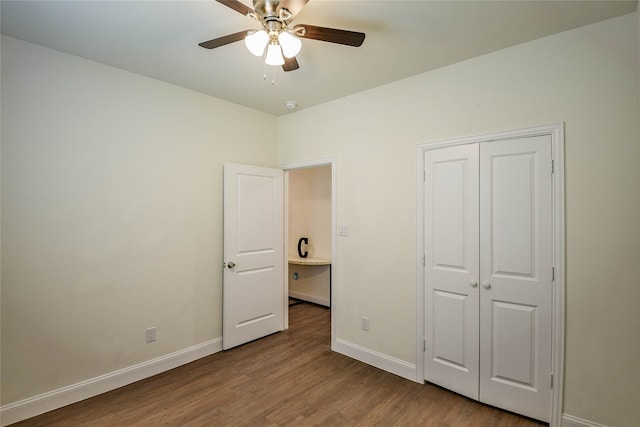 unfurnished bedroom with ceiling fan, a closet, and wood-type flooring