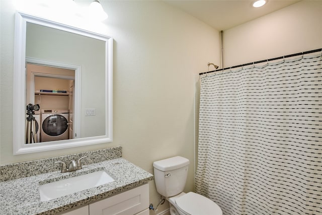 bathroom featuring a shower with shower curtain, vanity, toilet, and washer / dryer