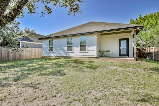 rear view of property with a yard and a patio area