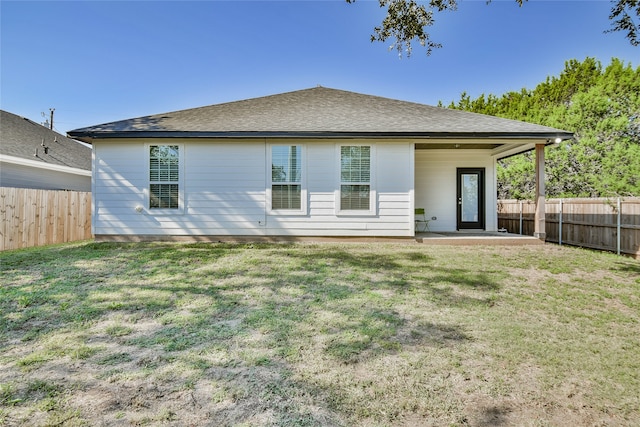 rear view of property featuring a patio and a lawn