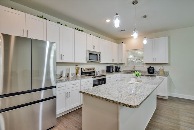 kitchen with dark hardwood / wood-style floors, white cabinetry, a center island, and stainless steel appliances