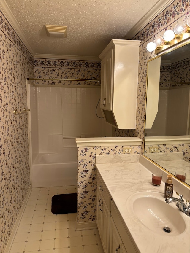 bathroom featuring vanity, crown molding, and a textured ceiling