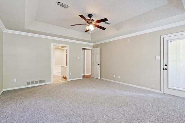 carpeted spare room featuring a raised ceiling, ceiling fan, ornamental molding, and a textured ceiling