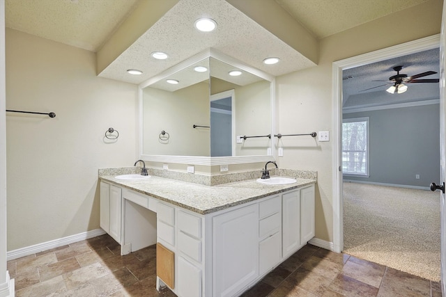 bathroom featuring ceiling fan, vanity, and a textured ceiling