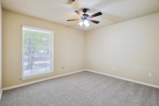 carpeted spare room with ceiling fan and a textured ceiling