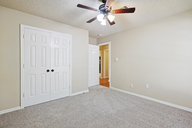 unfurnished bedroom with light carpet, ceiling fan, a closet, and a textured ceiling