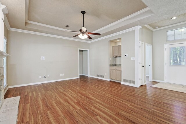 unfurnished living room with crown molding, ceiling fan, and wood-type flooring