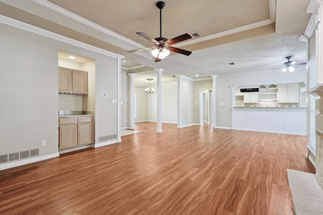 unfurnished living room with decorative columns, crown molding, light hardwood / wood-style floors, and a textured ceiling