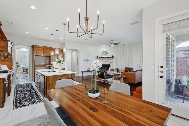 dining room with sink and ceiling fan with notable chandelier