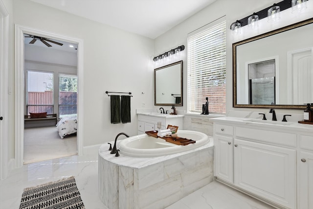 bathroom featuring vanity, a relaxing tiled tub, and ceiling fan