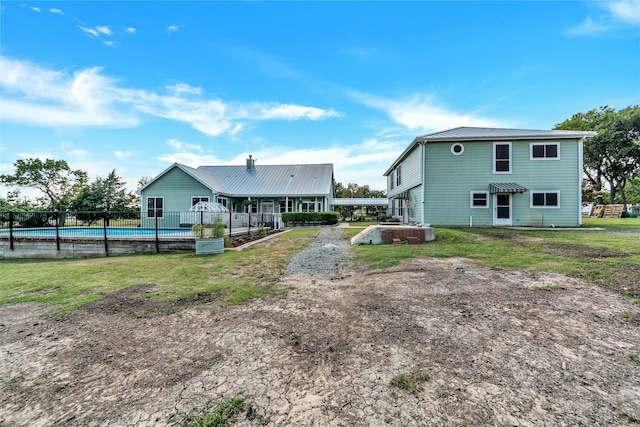 rear view of house featuring a pool