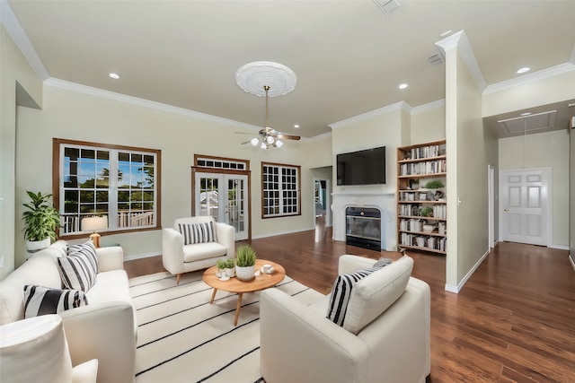 living room featuring dark wood-type flooring, ceiling fan, and crown molding