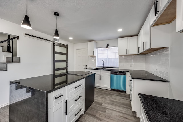 kitchen featuring hardwood / wood-style flooring, hanging light fixtures, a barn door, white cabinetry, and dishwasher