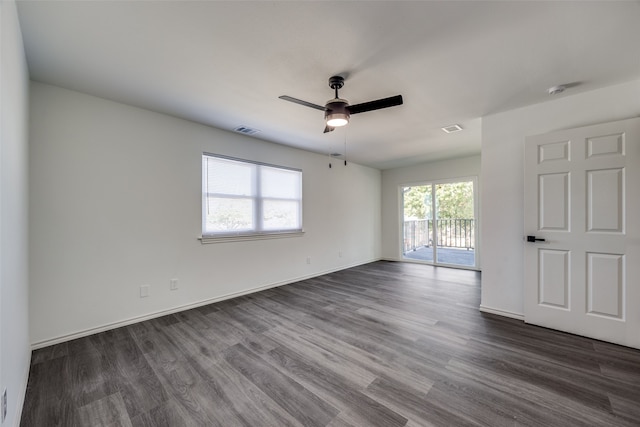 empty room with ceiling fan and dark wood-type flooring