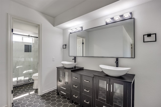 bathroom with tile patterned flooring, vanity, a shower with door, and toilet