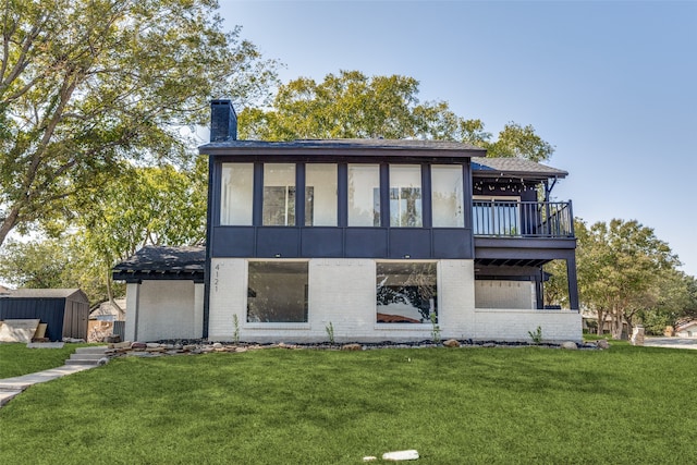 view of front of home featuring a deck, a storage shed, and a front yard