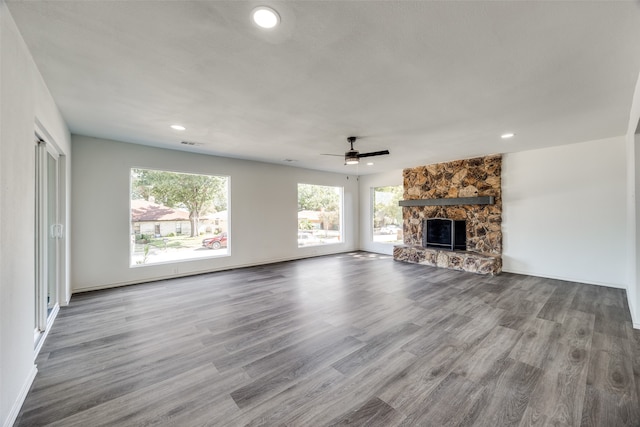 unfurnished living room featuring ceiling fan, a stone fireplace, and light hardwood / wood-style floors