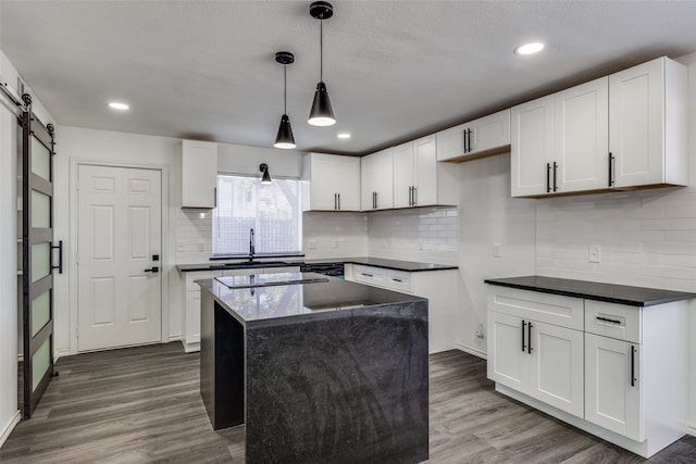 kitchen featuring a barn door, pendant lighting, dark hardwood / wood-style flooring, white cabinets, and a center island