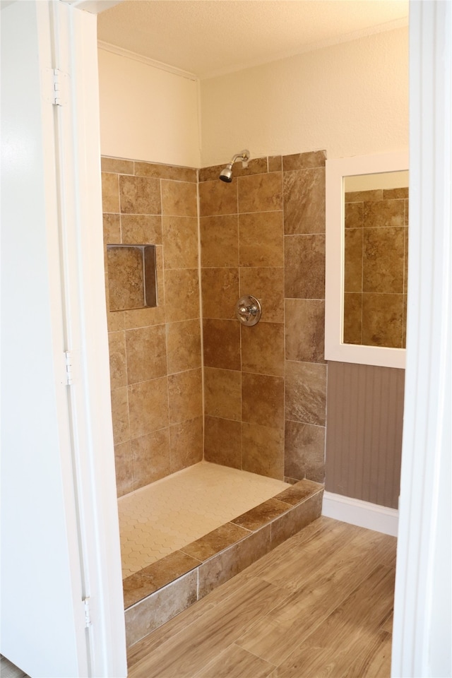 bathroom featuring wood-type flooring and a tile shower