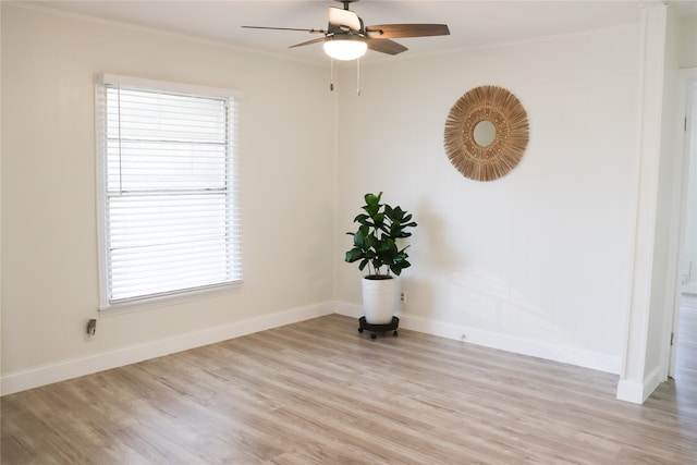 empty room with ceiling fan, light wood-type flooring, and crown molding