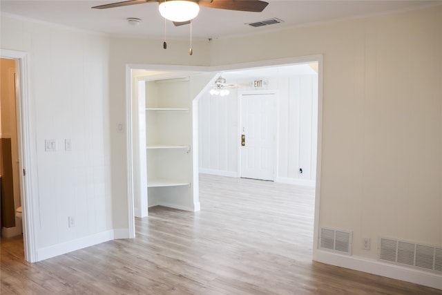 spare room featuring ceiling fan, light wood-type flooring, and ornamental molding